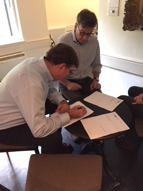 Adrian Cooper, CEO of Oxford Economics signing a contract in Oct 2014